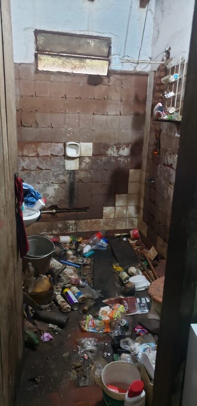 El baño con basura, objetos en descomposición.