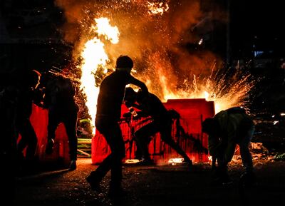 Manifestantes tras una barricada en llamas durante una protesta contra la violencia policial en Bogotá, el pasado jueves.