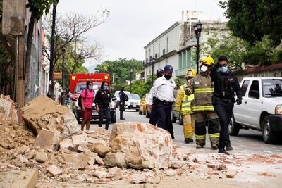 Miembros de la policía y de los bomberos observan los daños causados en una barda derrumbada este martes, en la ciudad de Oaxaca (México).
