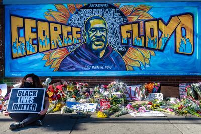 Flores, carteles y globos junto a un mural en memoria de George Floyd pintado cerca del sitio donde fue asesinado por la policía George Floy de Minneapolis.