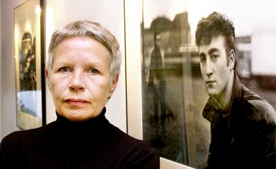 La fotógrafa Astrid Kirchnerr posando al lado de una de sus fotografías, durante una muestra.