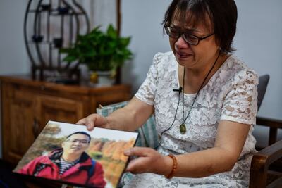 Zhong Hanneng muestra una foto de su hijo Peng Yi, quien murió por el coronavirus en Wuhan. Junto con otros familiares en duelo, quiere demandar al gobierno local al que culpa por su muerte.