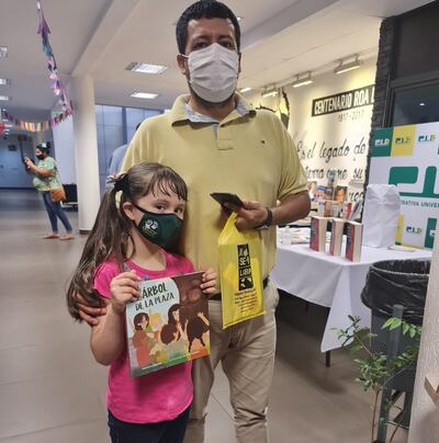 La libroferia tiene múltiples actividades y ofertas para personas de todas las edades. En la foto, un padre posa con su hija tras haber adquirido libros de la exposición.