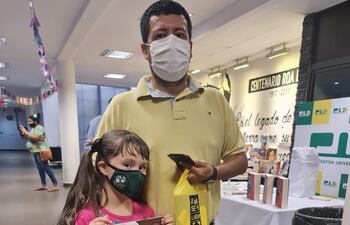 La libroferia tiene múltiples actividades y ofertas para personas de todas las edades. En la foto, un padre posa con su hija tras haber adquirido libros de la exposición.