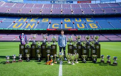 El futbolista Gerard Piqué con los 30 títulos que ganó con el FC Barcelona, en el césped del Camp Nou - FCB