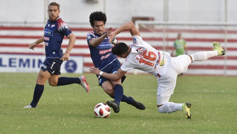 Ante la mirada de  Edgardo Orzusa (autor del gol albo), el capitán de Nacional, Cristian Riveros, disputa el balón con Ramón Sosa, que marcó el tanto de  River Plate.