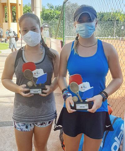 María Luján Alegre (i) y la chilena Martina Pavissich posan con sus trofeos de campeonas en dobles 16 años.
