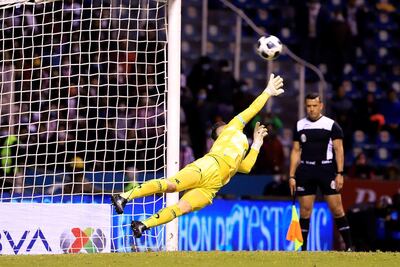 Antony Silva de Club Puebla desvía un tiro penal ante Guadalajara, durante un partido de reclasificación del Torneo Apertura 2021 de la Liga MX del fútbol mexicano, este sábado, en el estadio Cuauhtémoc de la ciudad de Puebla (México).