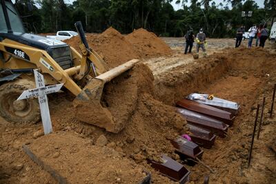 Una excavadora cubre los ataúdes enterrados en una fosa común en el cementerio de Nossa Senhora en Manaus, estado de Amazonas, Brasil.