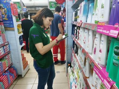 Un alumna de la Facultad de Ciencias Económica de la Universidad Nacional del Este en la tarea de recolectar datos en un supermercado.