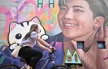 Una mujer pasa junto a un mural que retrata a RM en Goyang, Corea del Sur.