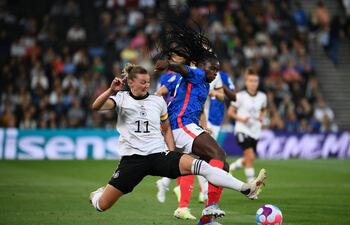 Alexandra Popp (i), la capitana de Alemania, hace un tackle a la jugadora francesa Griedge Mbock Bathy, durante el partido semifinal de la Eurocopa Femenina 2022 disputado ayer.