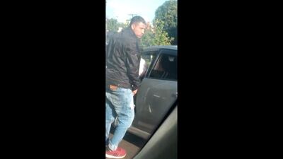 El asaltante cerca del automóvil que asaltó en la fila en cercanías del Puente de la Amistad, en Foz de Yguazú.