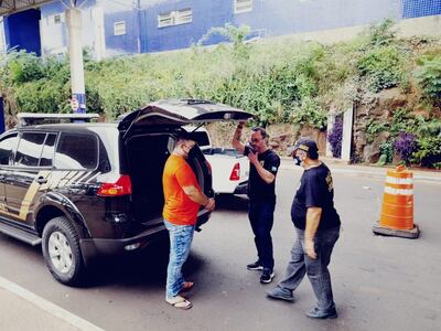 Arnaldo Andrés Escobar (a la izquierda), bajo custodia de agentes federales de Brasil.