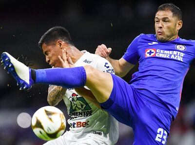 Pablo Aguilar, de Cruz Azul, disputa el balón con Roberto de la Rosa, de Pachuca.