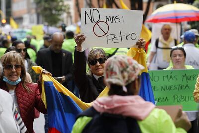 Personas con carteles y gritando consignas participan de una marcha contra las reformas del Gobierno del presidente colombiano Gustavo Petro, hoy en las calles de Bogotá (Colombia).