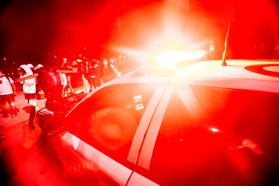 Manifestantes bloquean el paso a un auto de la policía en el sur de Los Ángeles.