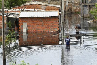 Personas caminan en el agua para llegar a sus casas e intentar retirar pertenencias en la zona de la Chacarita.