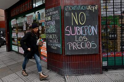 Una mujer camina junto a una tienda que advierte que no subieron los precios, en Buenos Aires.