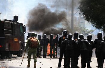 Policías antimotines se enfrentan a manifestantes hoy, en las calles de Quito (Ecuador).