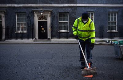 Un limpiador con mascarilla trabaja fuera de la residencia del primer ministro del Reino Unido, en Londres.