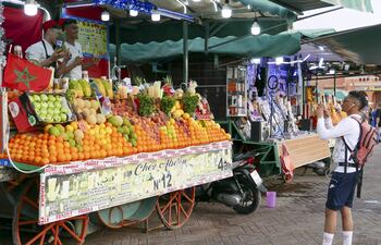 Dos vendedores de fruta posan para una foto en un mercado de Marrakech (Marruecos). Tras dos años de restricciones sanitarias, Marrakech, el pulmón turístico de Marruecos, está volviendo a la vida con plazas llenas de turistas y todos los comercios abiertos, aunque todavía no ha llegado a los niveles de visitantes prepandemia.