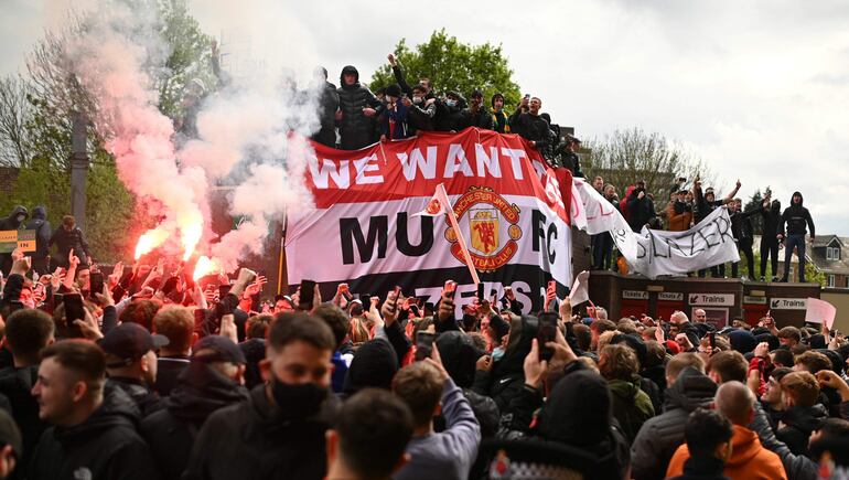 Supporters protest against Manchester United's owners, outside English Premier League club Manchester United's Old Trafford stadium in Manchester, north west England on May 2, 2021, ahead of their English Premier League fixture against Liverpool. - Manchester United were one of six Premier League teams to sign up to the breakaway European Super League tournament. But just 48 hours later the Super League collapsed as United and the rest of the English clubs pulled out. (Photo by Oli SCARFF / AFP)