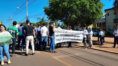 Funcionarios con pancartas sobre la ruta 14, frente al local comunal, en una huelga que inició hoy y fue anunciada por tiempo indefinido. Exigen contrato colectivo y reposición de funcionarios despedidos.