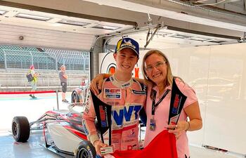 Junto a su madre Rommy Dick, Joshua posa con sus trofeos y la infaltable bandera paraguaya.