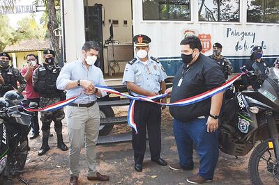 El intendente desata la cinta de inauguración de una comisaría móvil.