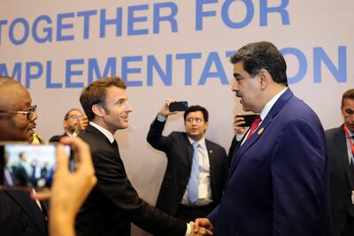 Handout picture released by the Venezuelan Presidency showing Venezuela's President Nicolas Maduro (R) shaking hands with French President Emmanuel Macron during the COP27 climate conference at the Sharm el-Sheikh International Convention Centre, in Egypt's Red Sea resort city of the same name, on November 7, 2022. (Photo by Handout / Venezuelan Presidency / AFP)