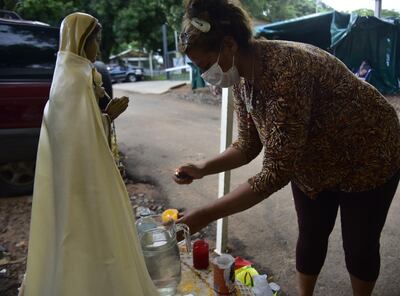Familiar prende una vela a la virgen apostada frente al Ineram.