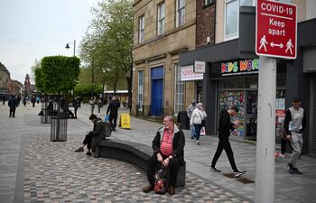 Un letrero pide a los miembros del público que se adhieran a las pautas actuales de distanciamiento social, ya que una variante de preocupación de Covid-19 está afectando a la comunidad en Bolton, noroeste de Inglaterra.