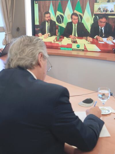El presidente de Argentina, Alberto Fernández, conversa con su par de Brasil, Jair Bolsonaro (c), durante la conferencia virtual, ayer.