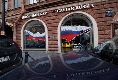 Un hombre con una mascarilla protectora camina frente a un negocio de venta de caviar en San Petersburgo, Rusia, el 19 de octubre de 2021.