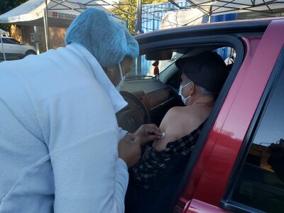 Un adulto  mayor recibe la vacuna contra el nuevo coronavirus en la Facultad de Derecho, modalidad autovac.