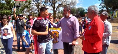 Yoao Rolón (I), con la bandera paraguaya desde el cuelo, a su llegada a la ciudad de Arroyos y Esteros.