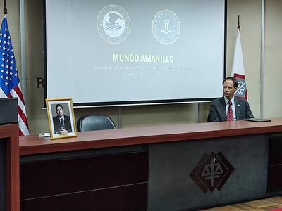 Brian Skaret, asesor legal de la oficina de justicia de EE.UU., junto a un retrato de Marcelo Pecci.