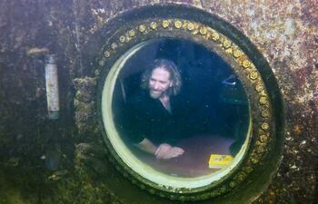 El explorador de buceo e investigador médico, Joseph Dituri (d), mientras saluda al buzo Thane Milhoan (i), el 13 de mayo, desde el Jules' Undersea Lodge, ubicado en el fondo de una laguna de 30 pies de profundidad en Cayo Largo, Florida (EEUU). El profesor de la Universidad del Sur de Florida y ex miembro de la Marina de EE.UU. Joseph Dituri, de 55 años, batió el récord mundial de permanencia bajo el agua al pasar 74 días consecutivos en un refugio submarino en los Cayos de Florida (sur de EE.UU.), donde aún seguirá hasta completar los 100 días.
