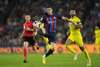 El delantero del FC Barcelona Robert Lewandowski (c) controla un balón ante Raúl Albiol (d), del Villarreal, durante el partido de la décima jornada de Liga en Primera División que disputaron ayer en el Camp Nou, en Barcelona. EFE/Alejandro García