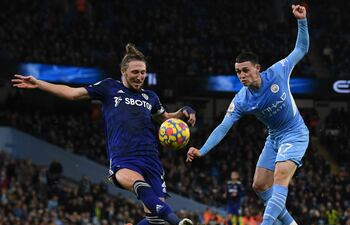 Phil Foden (d) remata el balón pese a la marca de Luke Ayling, del Leeds, durante el partido que City ganó ayer 7-0.