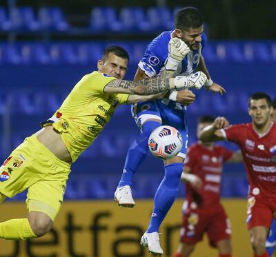 Arriesgada intervención del arquero de Nacional, Santiago Rojas, en el salto con el volante de 12 de Octubre, Juan Aguilar. No hubo gol anoche.