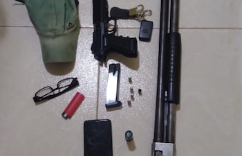 Las armas, cartuchos, celulares y otros objetos incautados.