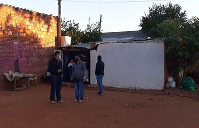 Investigadores de la Policía Nacional y funcionarios de la Fiscalía de Villa Elisa inspeccionan la vivienda donde Sara Leguizamón Medina fue baleada en la cabeza y falleció momentos después.