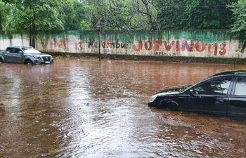 Dos de los vehículos que quedaron varados a raíz de la inundación de la avenida.