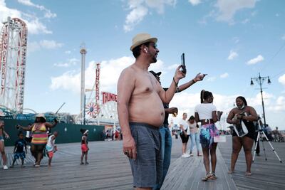 Neoryorquinos disfrutan de un día de playa en Coney Island y escapan del intenso calor.