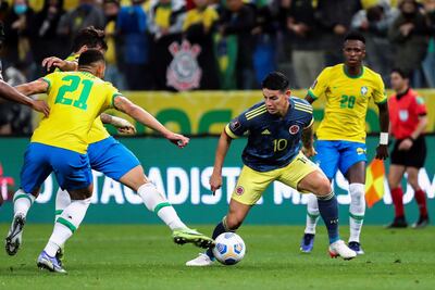 El colombiano James Rodríguez en acción con el balón contra tres jugadores de Brasil