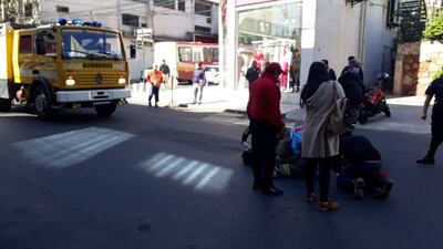 Mujer quedó tendida en el suelo, tras el choque en el centro de Asunción. (Gentileza).
