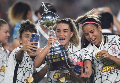 Tamires, capitana de Corinthians, levanta el trofeo de la Copa Libertadores rodeada de compañeras de equipo.