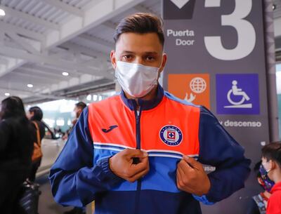 Ángel Romero, en el aeropuerto de México, muestra el escudo del Cruz Azul.